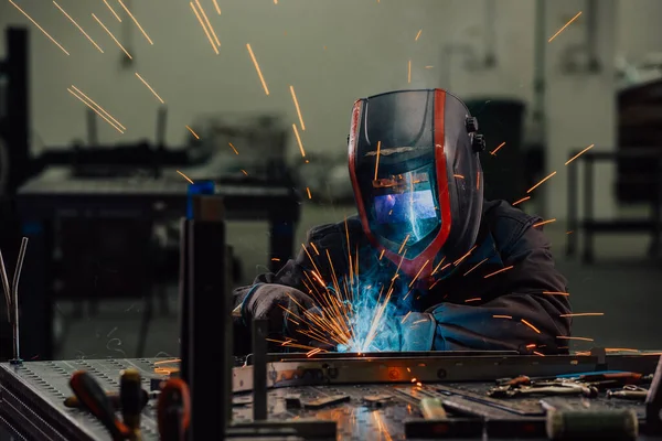 Professional Heavy Industry Welder Working Inside factory, Wears Helmet and Starts Welding. Selective Focus — Fotografia de Stock