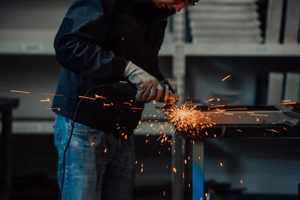 Nehézipari mérnöki gyár Belsőépítészet ipari dolgozókkal Angle Grinder használatával és egy fémcső vágásával. Vállalkozó biztonsági egyenruhában és keménykalapban Fémszerkezetek gyártása. — Stock Fotó