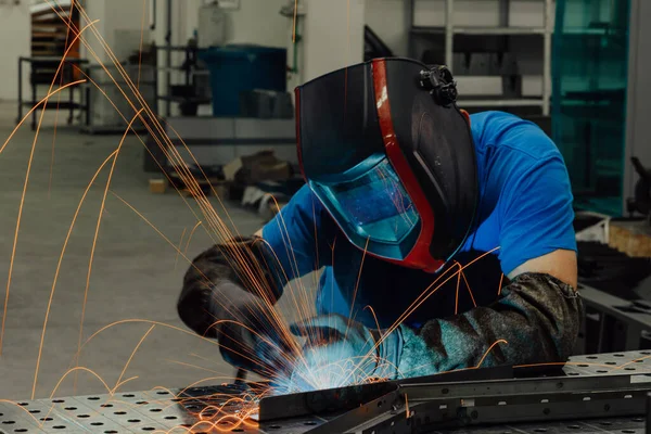 Professional Heavy Industry Welder Working Inside factory, Wears Helmet and Starts Welding. Selective Focus — Stock Fotó