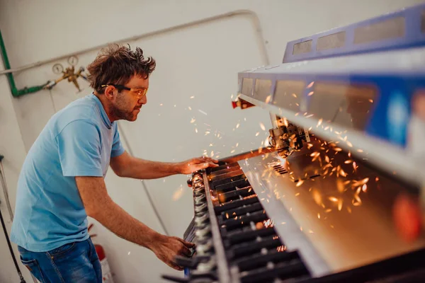 Within heavy industry. A man works in a modern factory on a CNC machine. Selective focus — Stok fotoğraf