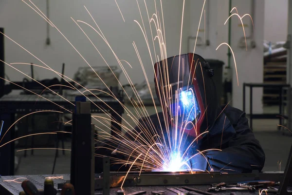 Professional Heavy Industry Welder Working Inside factory, Wears Helmet and Starts Welding. Selective Focus — Stok fotoğraf