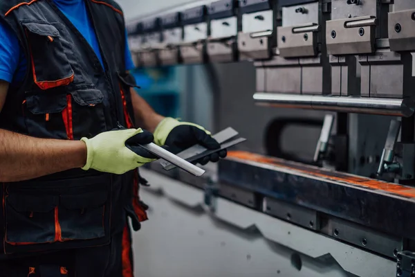 A smart factory worker or engineer makes machines in a production workshop. The concept of industry and engineering. Selective focus —  Fotos de Stock