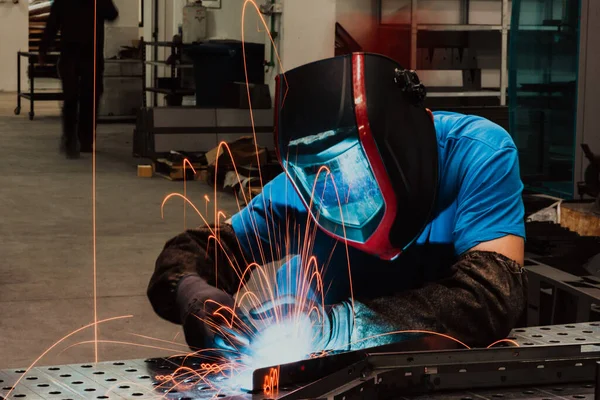 Professional Heavy Industry Welder Working Inside factory, Wears Helmet and Starts Welding. Selective Focus — Stock Fotó