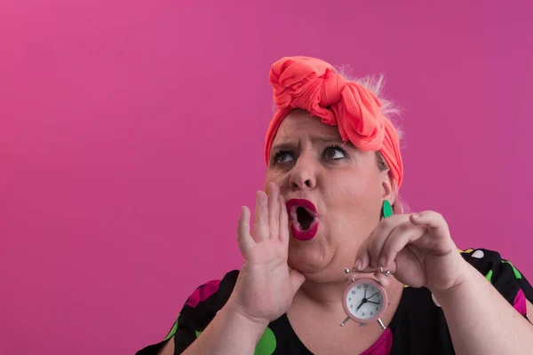 Retrato de plus size jovem senhora sorridente mãos mantém relógio de areia isolado no fundo cor-de-rosa. — Fotografia de Stock