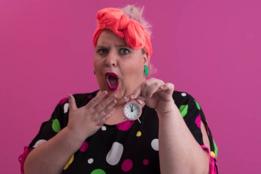 Büyük beden bir bayan portresi gülümseyen eller pembe arkaplanda izole edilmiş kum saati tutar..