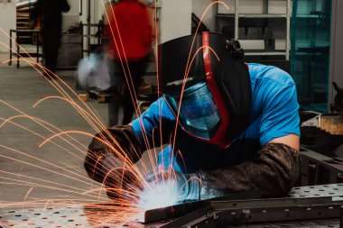 Professional Heavy Industry Welder Working Inside factory, Wears Helmet and Starts Welding. Selective Focus