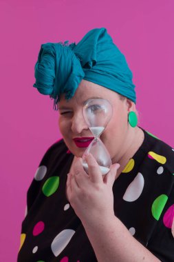 Büyük beden bir bayan portresi gülümseyen eller pembe arkaplanda izole edilmiş kum saati tutar..