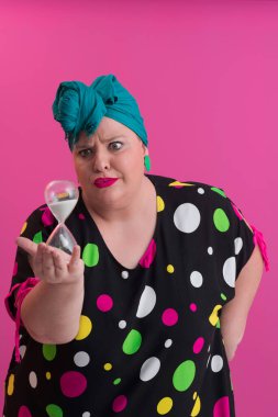 Büyük beden bir bayan portresi gülümseyen eller pembe arkaplanda izole edilmiş kum saati tutar..