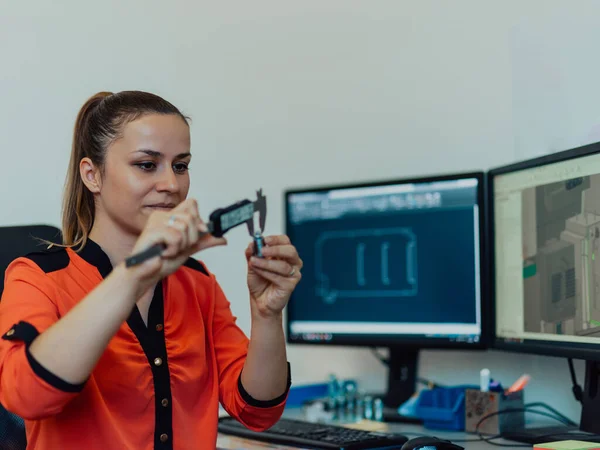 Within the heavy industry, a factory industrial engineer measures with a caliper and on a personal computer Designs a 3D model — Foto de Stock