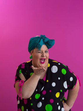 Artı, modaya uygun makyajlı seksi model kadın, stüdyoda pembe arka planda poz veren siyah kısa elbiseli şık sarışın..