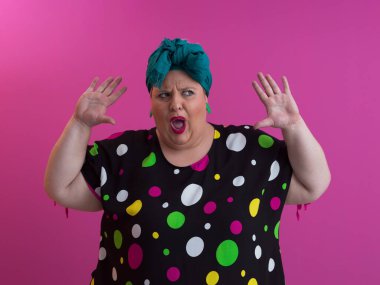 Artı, modaya uygun makyajlı seksi model kadın, stüdyoda pembe arka planda poz veren siyah kısa elbiseli şık sarışın..