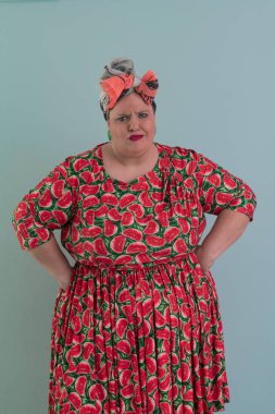 Artı, modaya uygun makyajlı seksi manken kadın, renkli elbiseli şık sarışın stüdyo ortamında veya açık mavi arka planda poz veren..