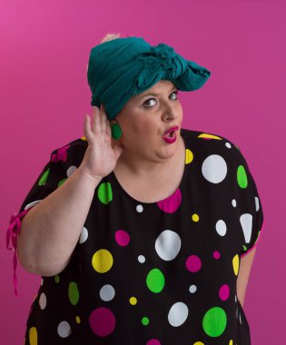 Artı, modaya uygun makyajlı seksi model kadın, stüdyoda pembe arka planda poz veren siyah kısa elbiseli şık sarışın..