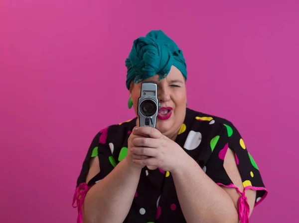 Más tamaño sonriente mujer con expresión de cara emocional divertida con cámara vintage en vestido aislado sobre fondo rosa, viajero de vacaciones, estilo de moda de verano, turista emocionado. —  Fotos de Stock