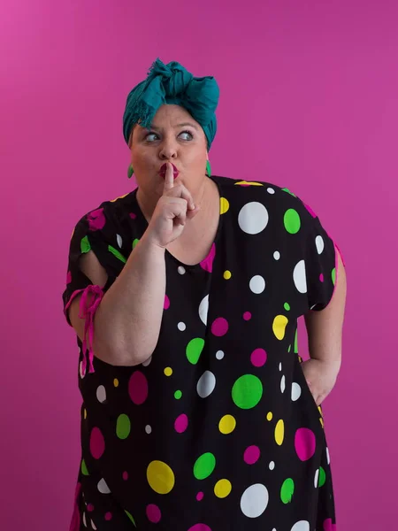 Plus size sexy model woman with trendy makeup, fashionable blonde in black short dress posing at the pink background in studio. — Fotografia de Stock