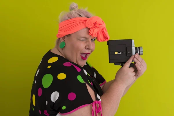 Más tamaño sonriente mujer con expresión de cara emocional divertida con cámara vintage en vestido aislado sobre fondo verde, viajero de vacaciones, estilo de moda de verano, turista emocionado. — Foto de Stock