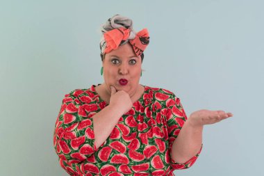 Artı, modaya uygun makyajlı seksi manken kadın, renkli elbiseli şık sarışın stüdyo ortamında veya açık mavi arka planda poz veren..