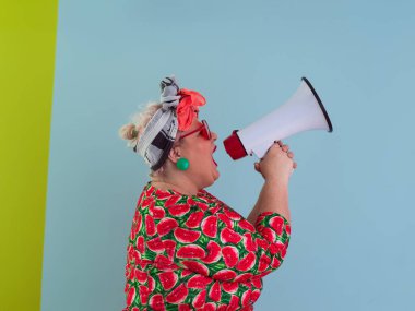 Cyan arkaplan stüdyo resminde izole edilmiş komik ve cüsseli bir kadın. Bir megafonda çığlık atmak. İnsanlar yaşam tarzı kavramını hisseder. Kopyalama alanı oluştur. 