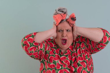 Artı, modaya uygun makyajlı seksi manken kadın, renkli elbiseli şık sarışın stüdyo ortamında veya açık mavi arka planda poz veren..