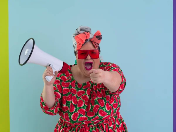 Cyan arkaplan stüdyo resminde izole edilmiş komik ve cüsseli bir kadın. Bir megafonda çığlık atmak. İnsanlar yaşam tarzı kavramını hisseder. Kopyalama alanı oluştur. 