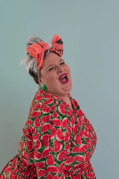 Artı, modaya uygun makyajlı seksi manken kadın, renkli elbiseli şık sarışın stüdyo ortamında veya açık mavi arka planda poz veren..