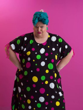 Artı, modaya uygun makyajlı seksi model kadın, stüdyoda pembe arka planda poz veren siyah kısa elbiseli şık sarışın..