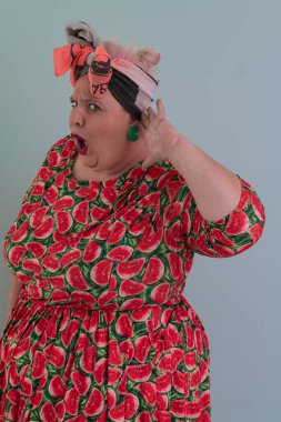 Artı, modaya uygun makyajlı seksi manken kadın, renkli elbiseli şık sarışın stüdyo ortamında veya açık mavi arka planda poz veren..