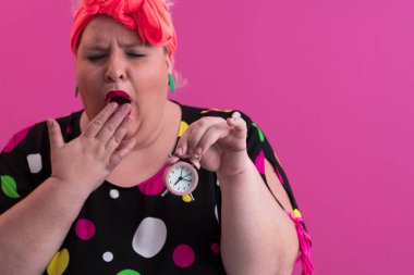 Büyük beden bir bayan portresi gülümseyen eller pembe arkaplanda izole edilmiş kum saati tutar..