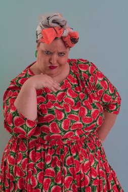 Artı, modaya uygun makyajlı seksi manken kadın, renkli elbiseli şık sarışın stüdyo ortamında veya açık mavi arka planda poz veren..