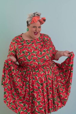 Artı, modaya uygun makyajlı seksi manken kadın, renkli elbiseli şık sarışın stüdyo ortamında veya açık mavi arka planda poz veren..