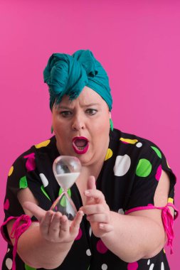 Büyük beden bir bayan portresi gülümseyen eller pembe arkaplanda izole edilmiş kum saati tutar..