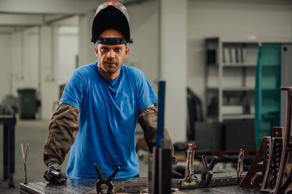 Portrait of Young Professional Heavy Industry Engineer. Worker Wearing Safety Vest and Hardhat Smiling on Camera. In the Background Unfocused Large Industrial Factory — Stockfoto