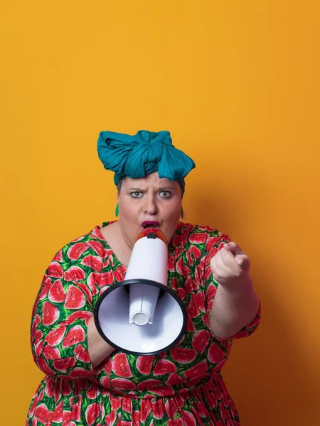 Engraçado mais tamanho mulher posando isolado no fundo amarelo estúdio retrato. Uma senhora de peso a gritar num megafone. Pessoas emoções conceito de estilo de vida. Mock up espaço de cópia. — Fotografia de Stock