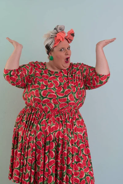 Artı, modaya uygun makyajlı seksi manken kadın, renkli elbiseli şık sarışın stüdyo ortamında veya açık mavi arka planda poz veren..