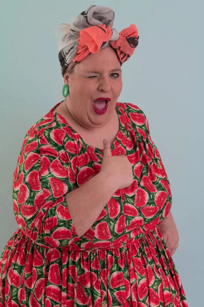 Artı, modaya uygun makyajlı seksi manken kadın, renkli elbiseli şık sarışın stüdyo ortamında veya açık mavi arka planda poz veren..