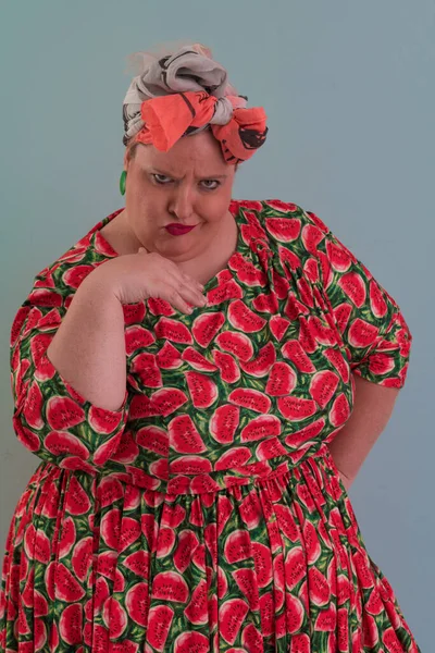 Artı, modaya uygun makyajlı seksi manken kadın, renkli elbiseli şık sarışın stüdyo ortamında veya açık mavi arka planda poz veren..