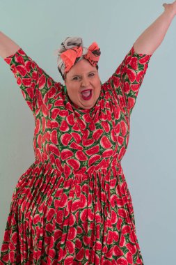 Artı, modaya uygun makyajlı seksi manken kadın, renkli elbiseli şık sarışın stüdyo ortamında veya açık mavi arka planda poz veren..