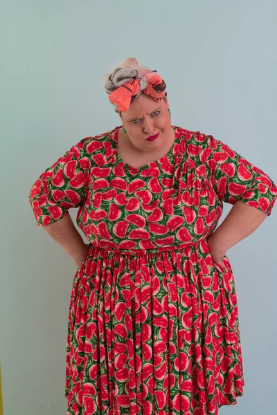 Artı, modaya uygun makyajlı seksi manken kadın, renkli elbiseli şık sarışın stüdyo ortamında veya açık mavi arka planda poz veren..