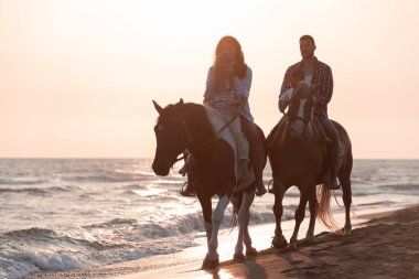 Aile kumlu bir sahilde birlikte ata binerken çocuklarıyla vakit geçirir. Seçici odak 