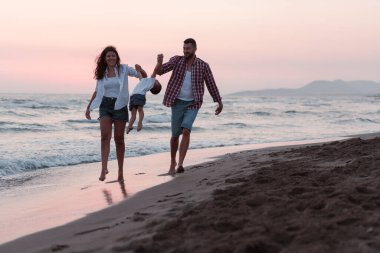 Aile, oğluyla kumsalda yürürken tatilin tadını çıkarıyor. Seçici odak 