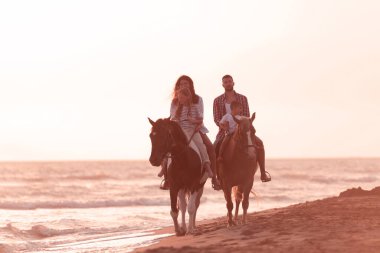 Aile kumlu bir sahilde birlikte ata binerken çocuklarıyla vakit geçirir. Seçici odak 