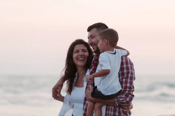 The family enjoys their vacation as they walk the sandy beach with their son. Selective focus — Stockfoto