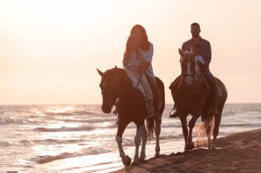 Aile kumlu bir sahilde birlikte ata binerken çocuklarıyla vakit geçirir. Seçici odak 
