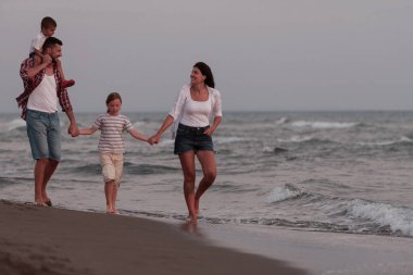 Aile toplantıları ve gün batımında sahilde sosyalleşme. Aile kumlu sahil boyunca yürür. Seçici odak 