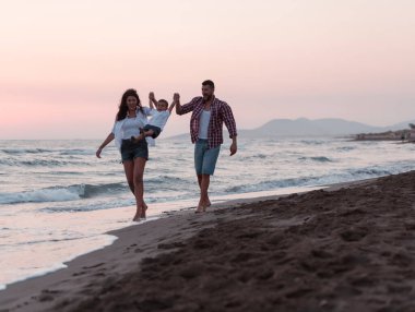 Aile, oğluyla kumsalda yürürken tatilin tadını çıkarıyor. Seçici odak 