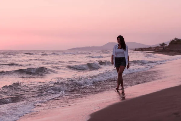 Szczęśliwa beztroska kobieta ciesząca się pięknym zachodem słońca na plaży. Skupienie selektywne — Zdjęcie stockowe