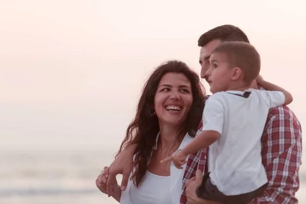The family enjoys their vacation as they walk the sandy beach with their son. Selective focus — Stockfoto