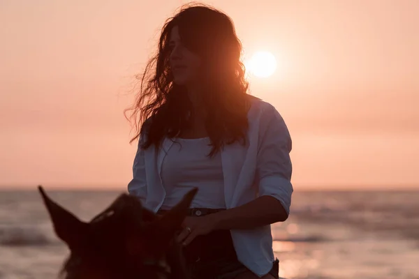 Vrouw in zomerkleding geniet van paardrijden op een prachtig zandstrand bij zonsondergang. Selectieve focus — Stockfoto