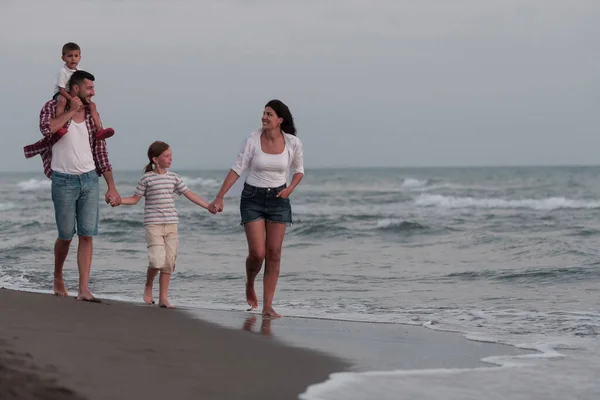 Familienfeiern und Geselligkeit am Strand bei Sonnenuntergang. Die Familie spaziert am Sandstrand entlang. Selektiver Fokus — Stockfoto