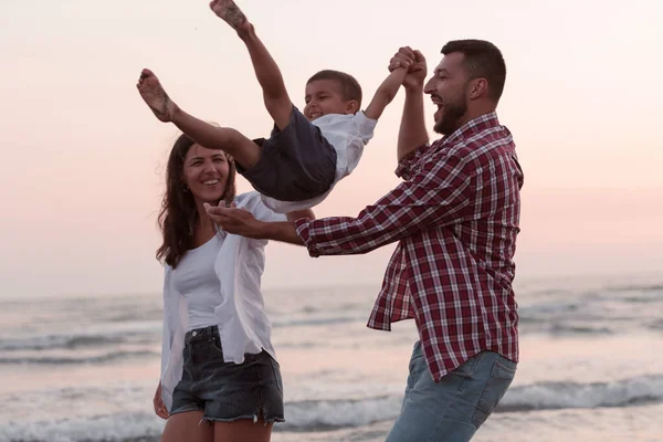 Die Familie genießt ihren Urlaub, während sie mit ihrem Sohn am Sandstrand spazieren geht. Selektiver Fokus — Stockfoto